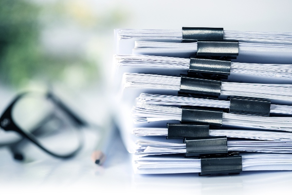 A stack of legal documents sits on a desk, ready to be served.